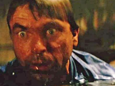 Close up of a terrified man neck deep in water.