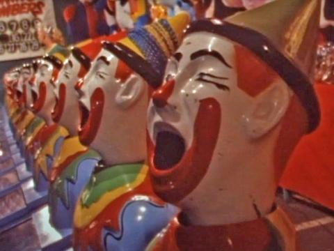 A row of open-mouthed clown heads from a sideshow alley game.