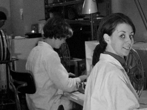 Women wearing white coats working behind the scenes at a TV studio