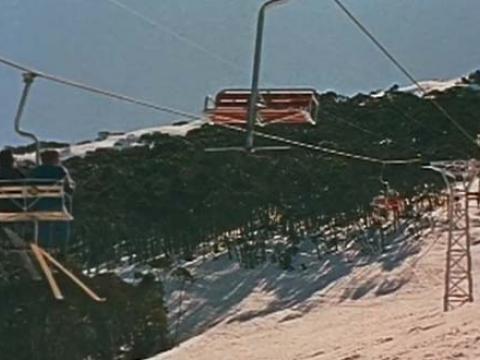 Two chairlifts travelling above the snow at Thredbo Alpine Village