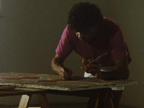 Jeffrey Samuels leaning over a table painting
