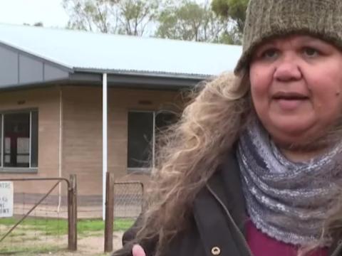 A head and shoulders shot of an Aboriginal woman wearing a beanie and scarf.