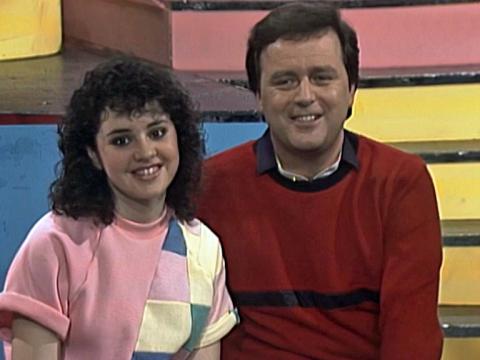 Tina Arena and Johnny Young on the set of Young Talent Time in 1983, both are smiling at the camera.