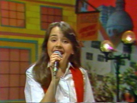 A young girl singing into a microphone.