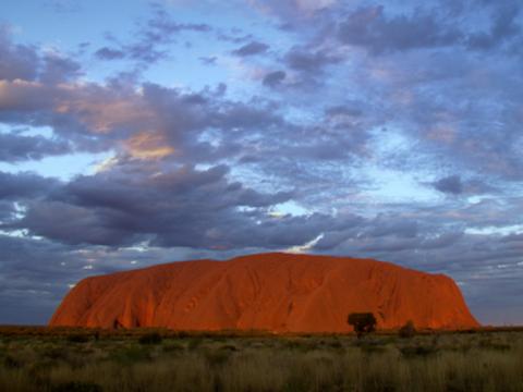 Wide shot of Uluru with blue cloudy sky