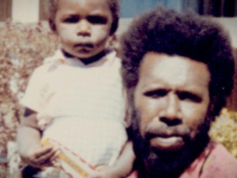 Aboriginal man Eddie 'Koiki Mabo holding a child