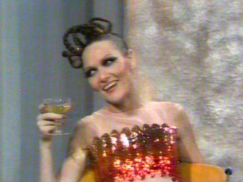 Jeanne Little is holding a glass of champagne.