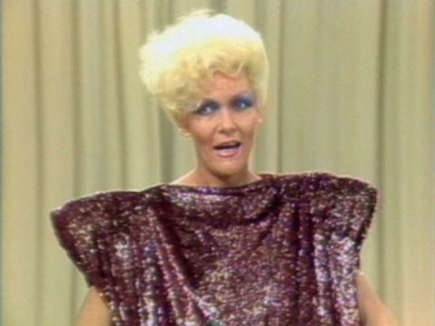 Jeanne Little is wearing a dress with wide shoulder pads.