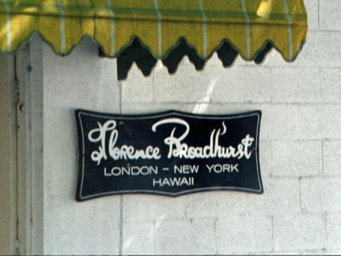 Shot of a yellow awning and business signage out the front of a building. The signage says 'Florence Broadhurst. London - New York - Hawaii' in white writing on a black background.