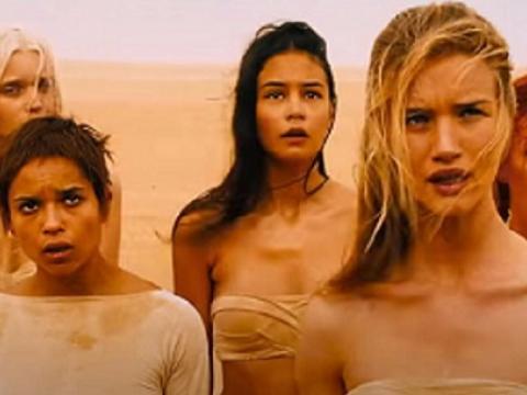 A group of five women standing in the desert.