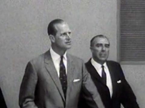 Prince Philip arrives at the Royal Australian Mint accompanied by a man in a business suit