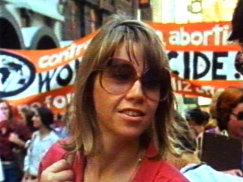 A woman in sunglasses with women behind her marching