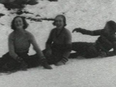 Three women laugh after crashing their toboggan