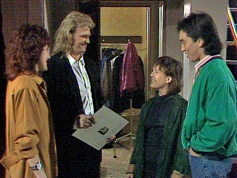 John Farnham in an appearance on the TV soap Home and Away. Standing in a hallway outside a dressing room backstage talking to 3 other people. 