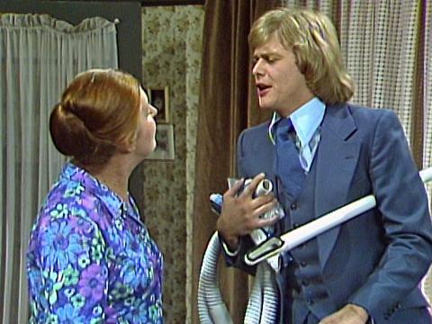 John Farnham, holding some vacuum cleaner hoses and talking to Rosie Sturgess in a scene from the TV sitcom The Last of The Australians.