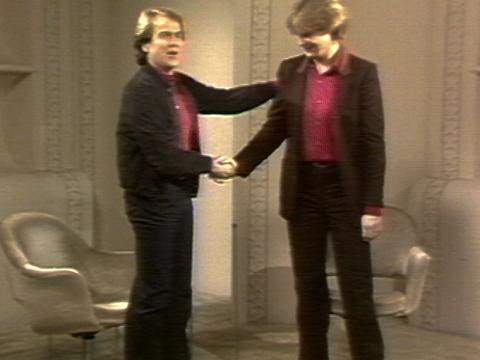 John Farnham and Glenn Shorrock standing on the set of The Mike Walsh show, shaking hands.