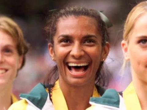 Nova Peris flanked by team mates receiving an Olympic gold medal