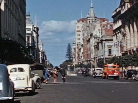 City street scene of Perth, circa 1940s. Cars line the streets and pedestrians are crossing the road. 