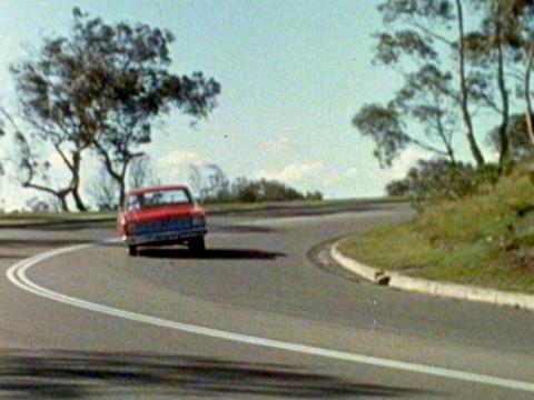 A vintage XT Falcon turning a corner. The car is learning over a lot.