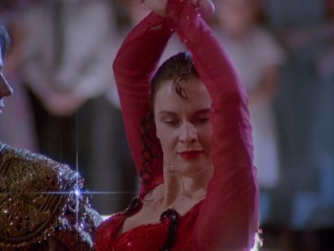 Head and shoulders shot of Scott (Paul Mercurio) and Fran (Tara Morice) in Spanish costume dancing the Paso Doble at a ballroom dancing competition. 