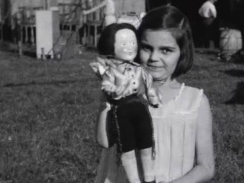 A little girl holds a doll