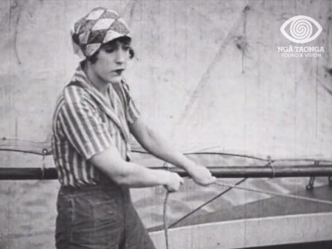 Black and white image of Annette Kellerman sailing a boat.