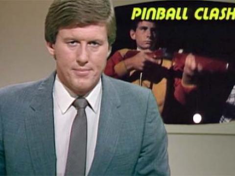 A newsreader presenting a story entitled 'Pinball Clash'