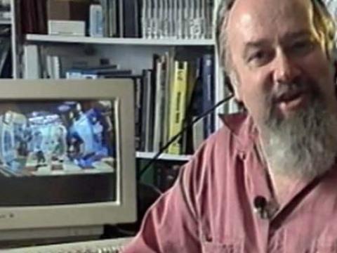 Bearded man sitting by a computer