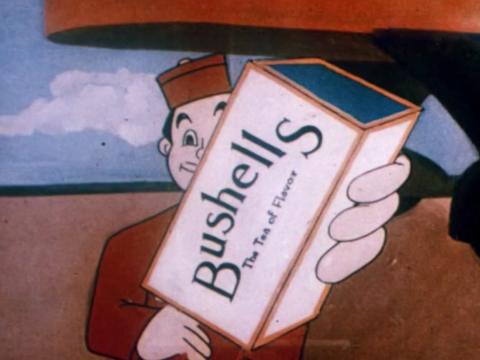 A shot from an animated commercial showing a man in a red uniform and hat holding up a box of Bushell's brand tea.