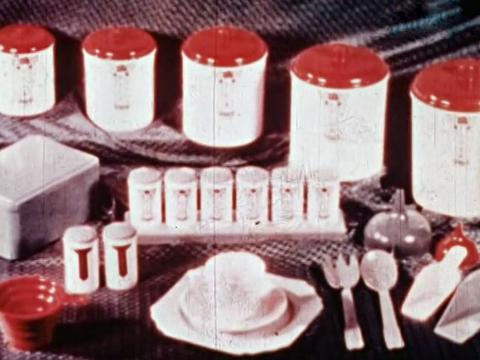 A shot from a commercial showing a display of crockery, cannisters, cutlery and other household, kitchen items.