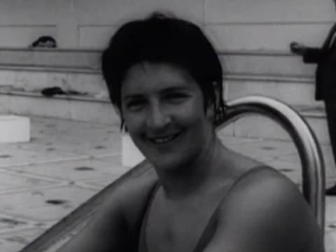 Black and white image of Dawn Fraser seated by the pool