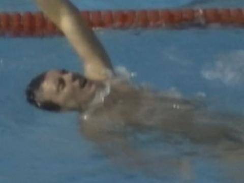 John Seiben floats on his back in the pool after winning his race