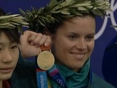 Chantelle Newberry holding her gold medal with a laurel reef on her head