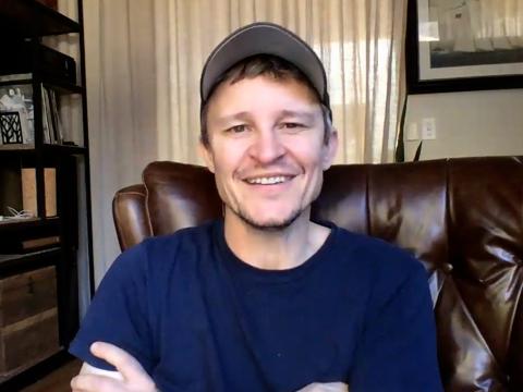 Head and shoulders shot of actor Damon Herriman smiling at camera