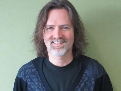 Head and shoulders portrait of composer David Hirschfelder looking into camera