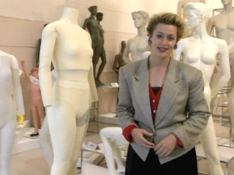 Amanda Keller stands in front a group of mannequins. The mannequins are in various states of undress.