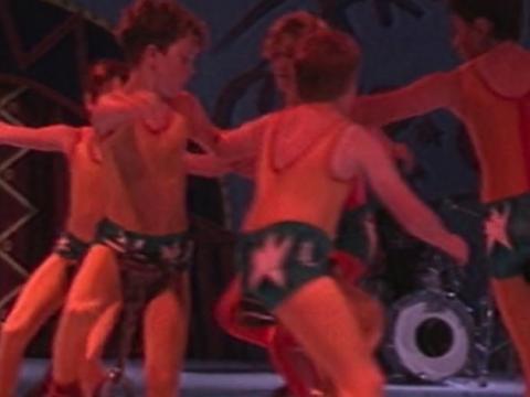 A group of boys performing on unicycles