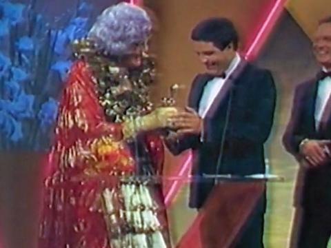 Dame Edna Everage hands a TV Week logie award to Simon Townsend
