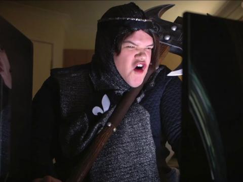 Person wearing fake armour yelling at a computer screen.