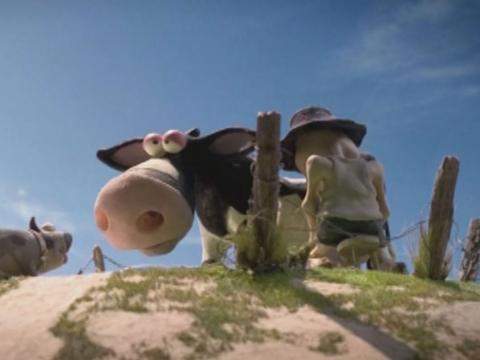 Animation still of a man milking a cow.