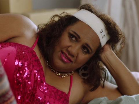 Indigenous woman wearing red sequinned dress lying down
