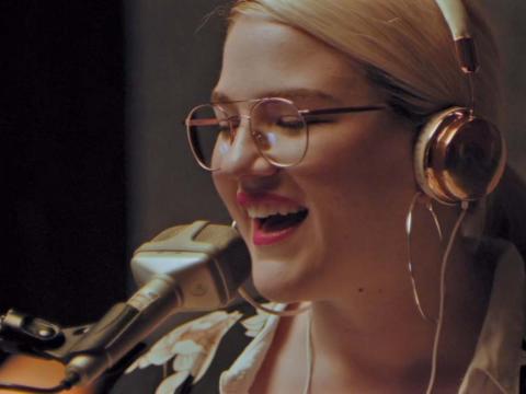 Close up of a young woman at a microphone in a radio station