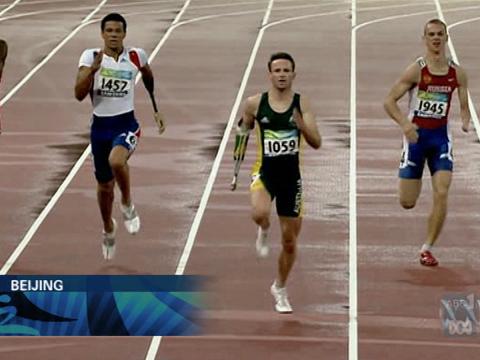 Four Paralympic athletes - Heath Francis and three others - run down a stretch of the track at the 2008 Beijing Paralympics facing the camera.
