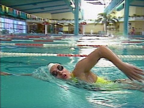 Paralympic swimmer Priya Cooper swims in a pool. She is swimming freestyle.