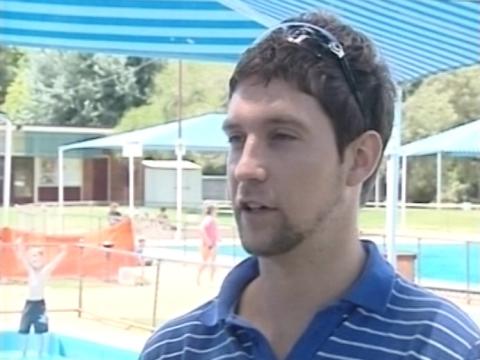 Paralympic swimmer Ben Austin is being interviewed at a local pool.