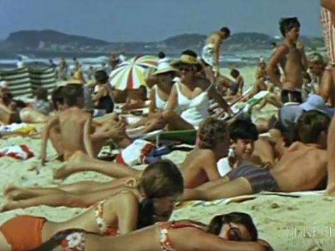 Crowd of people in swimsuits sunbathing on Bondi beach, circa 1970