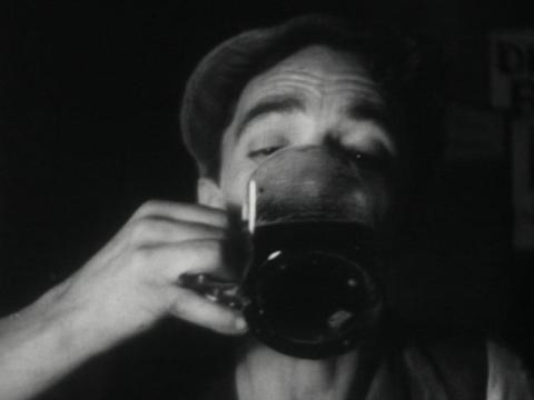 A man drinks from a large beer glass