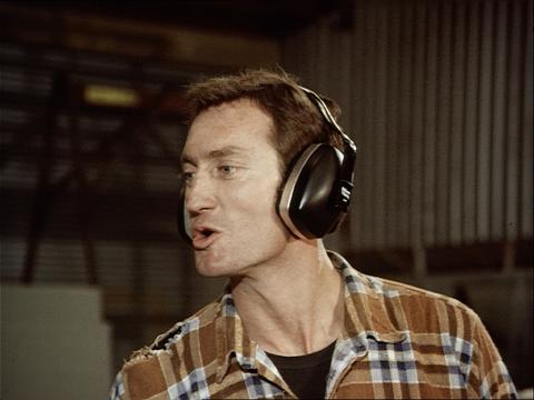 Actor Bryan Brown, wearing hearing protective equipment, in the 1981 short film Noise