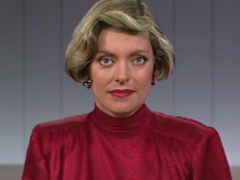 A news anchor looks down the camera