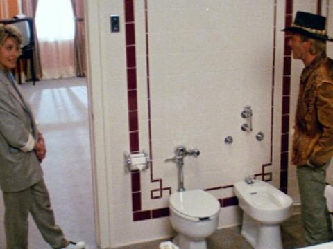 Video still of Mick Dundee (Paul Hogan) talking to Sue Charlton (Linda Kozlowski) about the two dunnies he's found in his hotel room in New York City